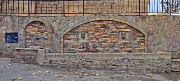 Fuente de los Lobos, en la localidad de Huéneja. Es una fuente urbana con abrevadero. No sale agua de continuo, sino que, dispone de un grifo. Era un antiguo manantial que ahora echa agua de la red de abastecimiento. Los sedimentos detríticos tienen una buena permeabilidad y los metamórficos les hacen de sustrato impermeable. Los primeros se comportan de este modo como un acuífero capaz de transmitir y almacenar agua, infiltrada desde las escorrentias de Sierra Nevada. Estos recursos han sido históricamente aprovechados mediante la construcción de pozos o de galerías, que han propiciado la consolidación de estos asentamientos, como es el caso de la población de Huéneja.